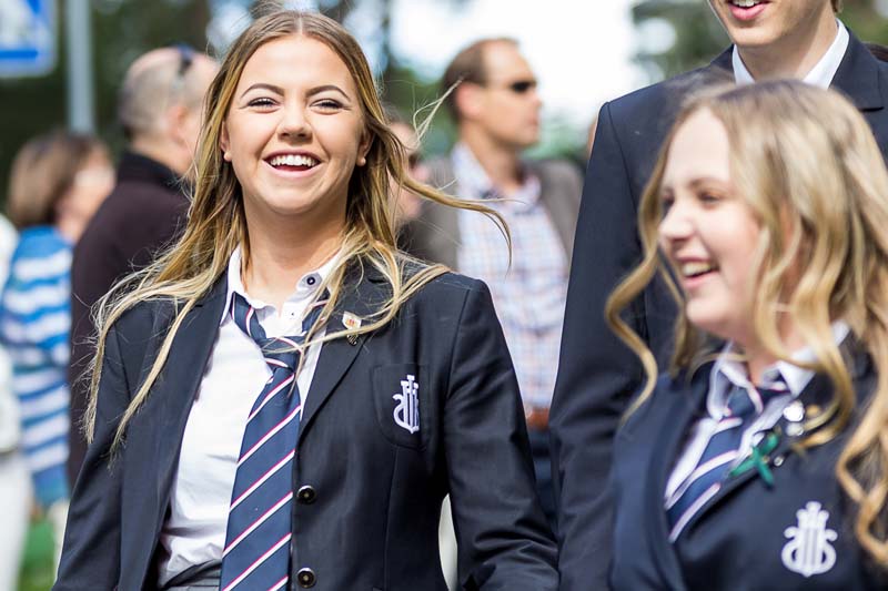 Glada elever i solsken och skoluniform