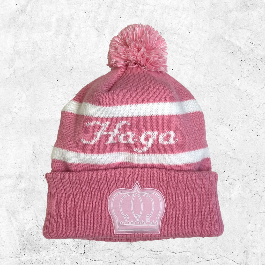 Klassisk vintermössa i Hagas färger rosa och vit, med elevhemmets emblem.